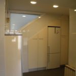 Reforma de baño con armarios y frigorífico bajo escalera